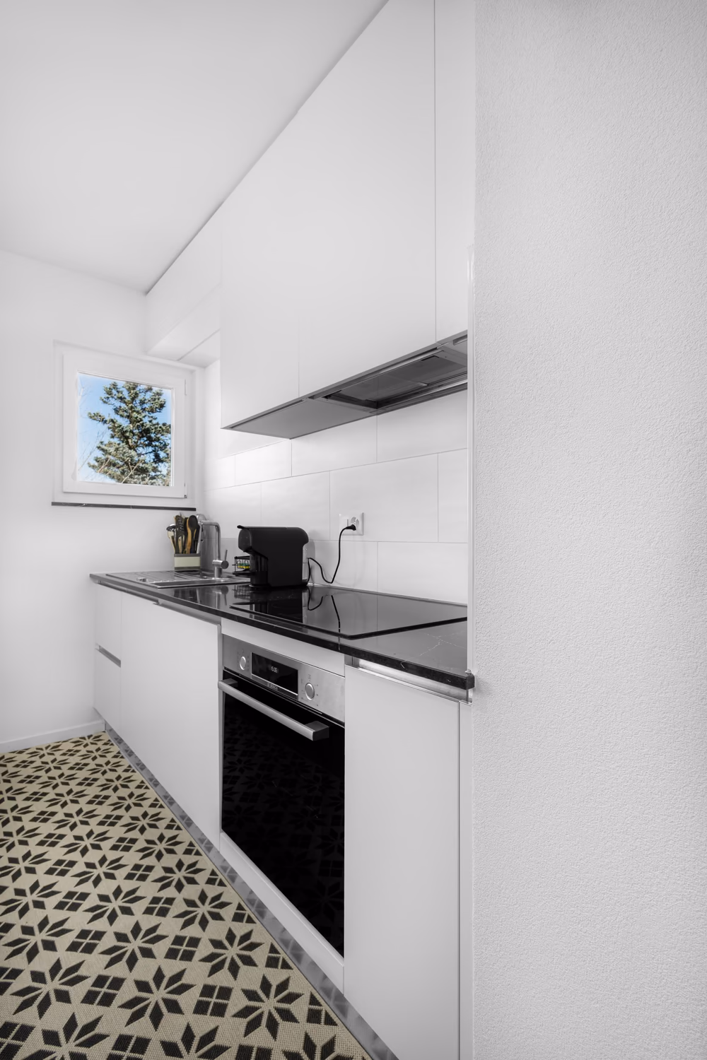 Cuisine blanche compacte adaptée à une pièce étroite